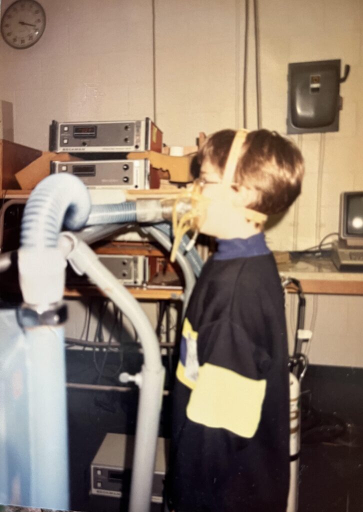 The author as an 8-10 year old standing on a treadmill hooked up to a metabolic cart.